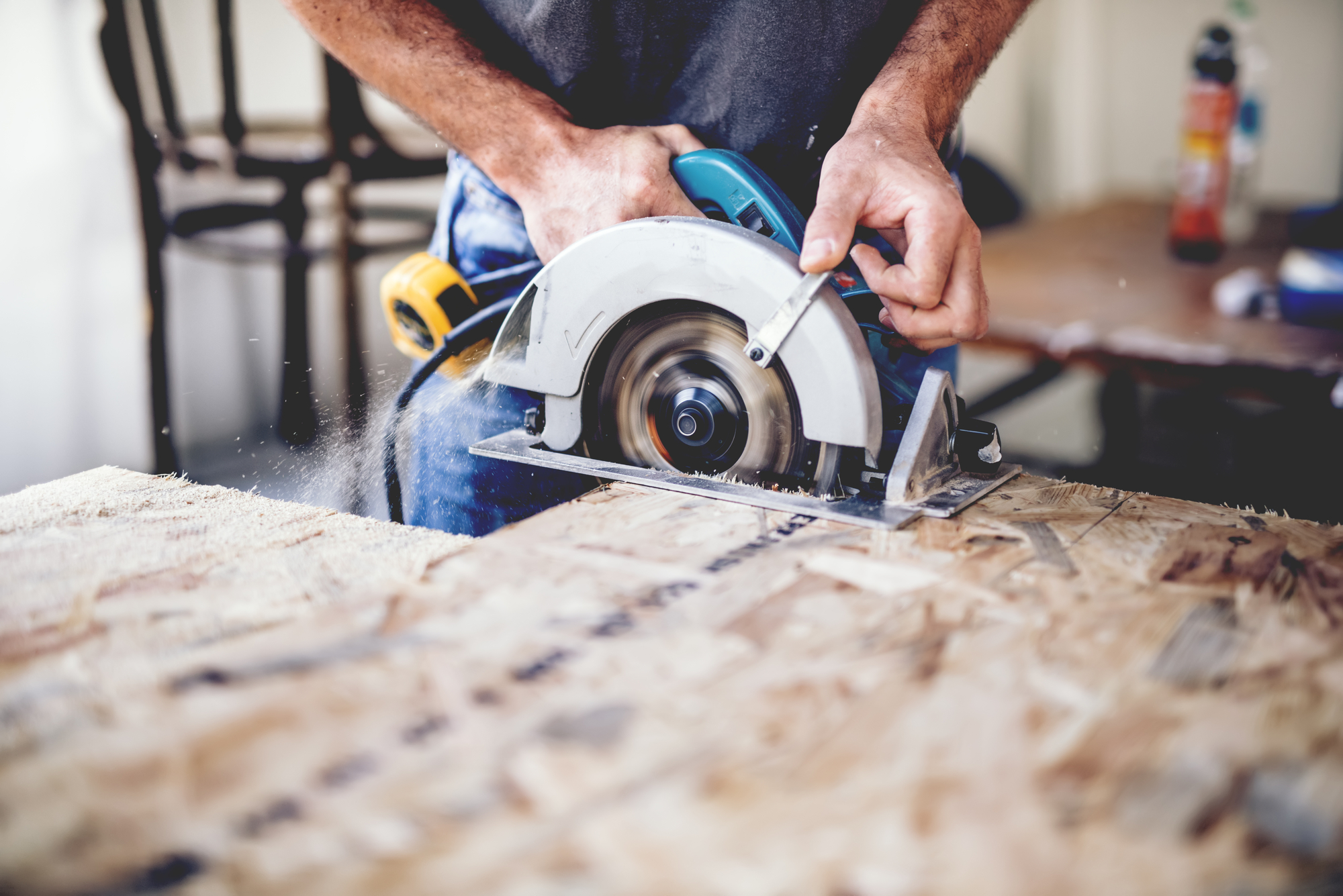 Carpenter Using Circular Saw For Cutting Wooden Boards